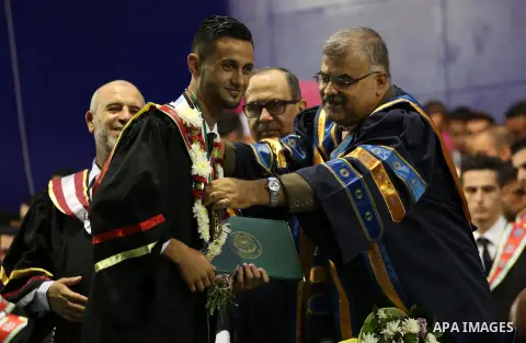 Palestinian students participate in their graduation ceremony at the Islamic University in Gaza city on July 23, 2016. Photo by Mohammed Asad