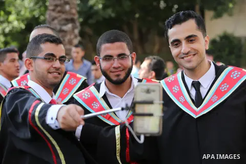 Palestinian students participate in their graduation ceremony at the Islamic University in Gaza city on July 23, 2016. Photo by Mohammed Asad