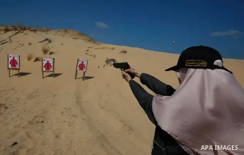 A Palestinian woman fires at a target during a training session for the families of Hamas officials, organized by Hamas-run Security and Protection Service, in Khan Younis in the southern Gaza Strip July 24, 2016. Photo...