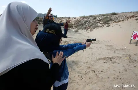 A Palestinian woman fires at a target during a training session for the families of Hamas officials, organized by Hamas-run Security and Protection Service, in Khan Younis in the southern Gaza Strip July 24, 2016. Photo...