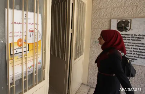A Palestinian woman looks for her name on the registered voters' list at Voter registration centers in the West Bank city of Nablus on July 24, 2016. The Palestinian Central Elections Commission (CEO) announced Saturday...