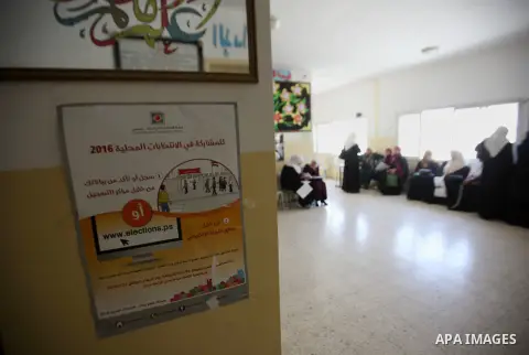 Palestinians look for their names on the registered voters' list at Voter registration centers in the West Bank city of Nablus on July 24, 2016. The Palestinian Central Elections Commission (CEO) announced Saturday that...
