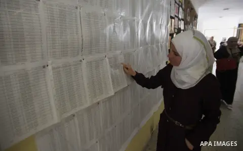 A Palestinian woman looks for her name on the registered voters' list at Voter registration centers in the West Bank city of Nablus on July 24, 2016. The Palestinian Central Elections Commission (CEO) announced Saturday...