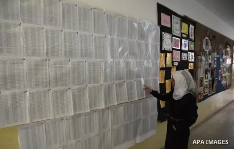 A Palestinian woman looks for her name on the registered voters' list at Voter registration centers in the West Bank city of Nablus on July 24, 2016. The Palestinian Central Elections Commission (CEO) announced Saturday...