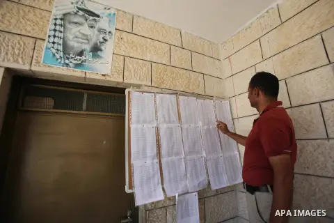 A Palestinian man looks for his name on the registered voters' list at Voter registration centers in the West Bank city of Nablus on July 24, 2016. The Palestinian Central Elections Commission (CEO) announced Saturday th...