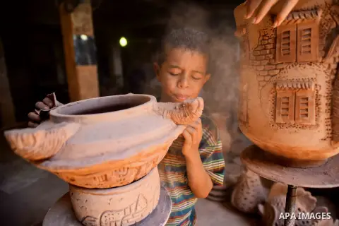 An Egyptian boy works at a pottery workshop in Cairo, on July 24, 2016. Pottery is an ancient and traditional craft in Egypt. Local workshops usually produce products such as bowls, pitchers, flower pots, and vases. Phot...