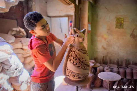 An Egyptian boy works at a pottery workshop in Cairo, on July 24, 2016. Pottery is an ancient and traditional craft in Egypt. Local workshops usually produce products such as bowls, pitchers, flower pots, and vases. Phot...