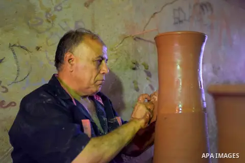 An Egyptian man uses a pottery wheel to construct a clay vessel, at a pottery workshop in Cairo, on July 24, 2016. Pottery is an ancient and traditional craft in Egypt. Local workshops usually produce products such as bo...