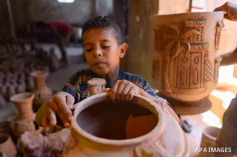 An Egyptian boy works at a pottery workshop in Cairo, on July 24, 2016. Pottery is an ancient and traditional craft in Egypt. Local workshops usually produce products such as bowls, pitchers, flower pots, and vases. Phot...