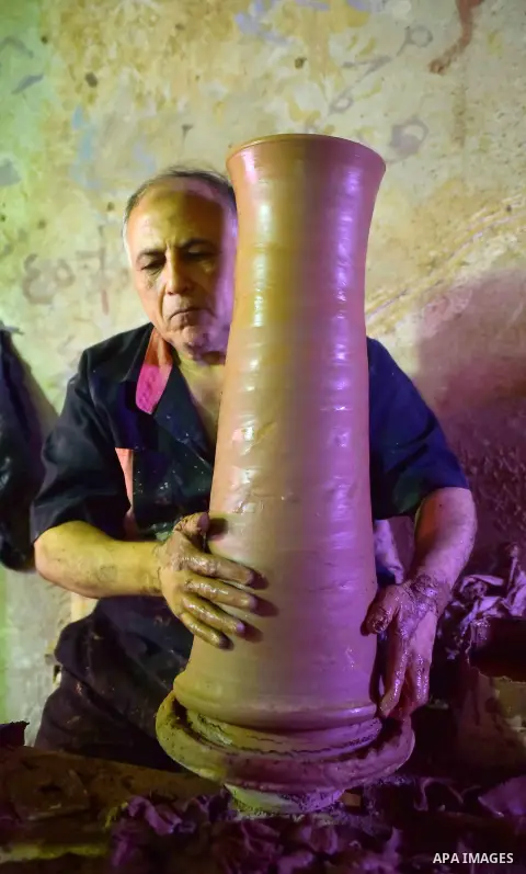 An Egyptian man uses a pottery wheel to construct a clay vessel, at a pottery workshop in Cairo, on July 24, 2016. Pottery is an ancient and traditional craft in Egypt. Local workshops usually produce products such as bo...