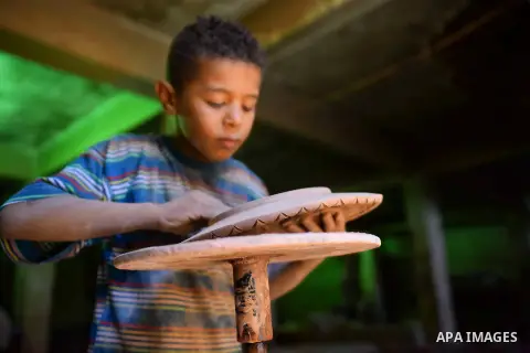 An Egyptian boy works at a pottery workshop in Cairo, on July 24, 2016. Pottery is an ancient and traditional craft in Egypt. Local workshops usually produce products such as bowls, pitchers, flower pots, and vases. Phot...
