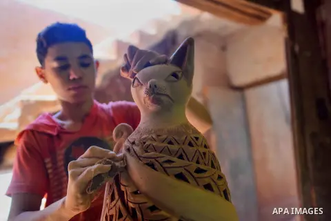 An Egyptian boy works at a pottery workshop in Cairo, on July 24, 2016. Pottery is an ancient and traditional craft in Egypt. Local workshops usually produce products such as bowls, pitchers, flower pots, and vases. Phot...