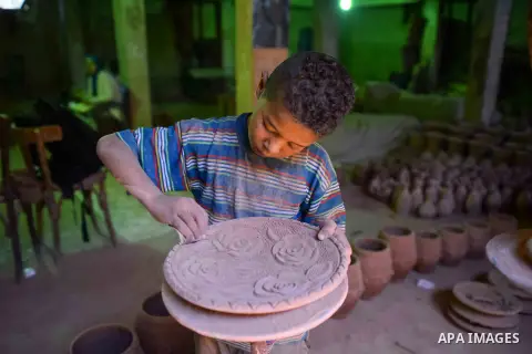An Egyptian boy works at a pottery workshop in Cairo, on July 24, 2016. Pottery is an ancient and traditional craft in Egypt. Local workshops usually produce products such as bowls, pitchers, flower pots, and vases. Phot...