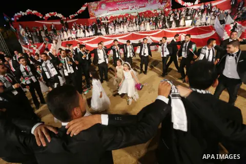 Palestinian grooms take part during a mass wedding for 340 couples organized by Hamas movement in Beit Lahiya town in the northern Gaza Strip July 24, 2016. Photo by Mohammed Asad