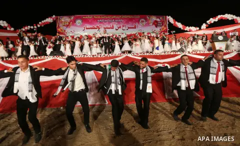 Palestinian grooms take part during a mass wedding for 340 couples organized by Hamas movement in Beit Lahiya town in the northern Gaza Strip July 24, 2016. Photo by Mohammed Asad