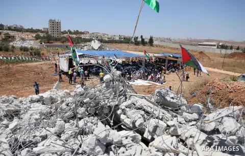 Palestinian Muslim worshippers perform the Friday prayer next to the rubble of the Palestinian homes that were destroyed by Israeli authorities three days before, on July 29, 2016 in the village of Qalandia, which is loc...