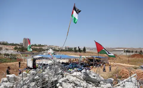 Palestinian Muslim worshippers perform the Friday prayer next to the rubble of the Palestinian homes that were destroyed by Israeli authorities three days before, on July 29, 2016 in the village of Qalandia, which is loc...