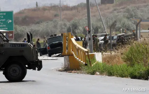 Israeli soldiers gather next to a vehicle belonging to a Palestinian man after he reportedly charged it into a group of soldiers at the Israeli army Hawara checkpoint near the city of Nablus in the occupied West Bank on...