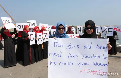 Palestinian girls hold banners during a protest to mark the second anniversary of the 50-day Israeli war on Gaza Strip last summer, in Gaza seaport Aug. 03, 2016. July 8th marks the two-year anniversary of the war betwee...
