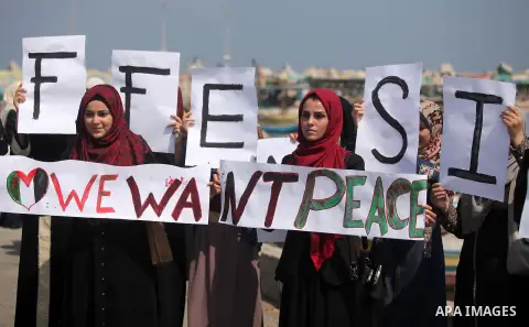 Palestinian girls hold banners during a protest to mark the second anniversary of the 50-day Israeli war on Gaza Strip last summer, in Gaza seaport Aug. 03, 2016. July 8th marks the two-year anniversary of the war betwee...