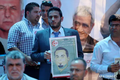 Palestinians take part in a protest demanding for the release of Bilal Kayed a Palestinian prisoner on hunger strike, in the West Bank city Ramallah on Aug. 03, 2016. Kayed who was due to be released after serving a 14-a...