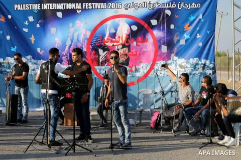 Palestinian band Dawaween, who were denied access to perform at a festival in Jerusalem, deliver a performance as part of a protest against the denial in Beit Hanun, near the Erez crossing point with Israel, in the north...