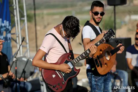 Palestinian band Dawaween, who were denied access to perform at a festival in Jerusalem, deliver a performance as part of a protest against the denial in Beit Hanun, near the Erez crossing point with Israel, in the north...