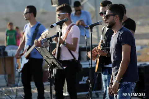 Palestinian band Dawaween, who were denied access to perform at a festival in Jerusalem, deliver a performance as part of a protest against the denial in Beit Hanun, near the Erez crossing point with Israel, in the north...