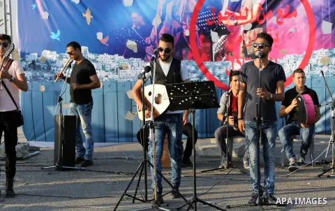 Palestinian band Dawaween, who were denied access to perform at a festival in Jerusalem, deliver a performance as part of a protest against the denial in Beit Hanun, near the Erez crossing point with Israel, in the north...