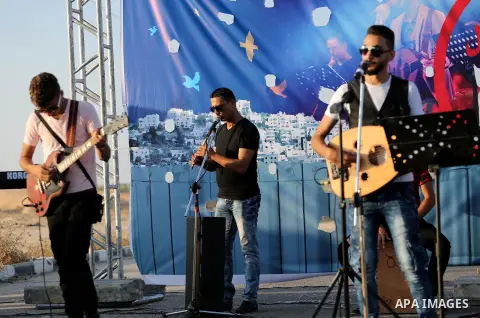 Palestinian band Dawaween, who were denied access to perform at a festival in Jerusalem, deliver a performance as part of a protest against the denial in Beit Hanun, near the Erez crossing point with Israel, in the north...