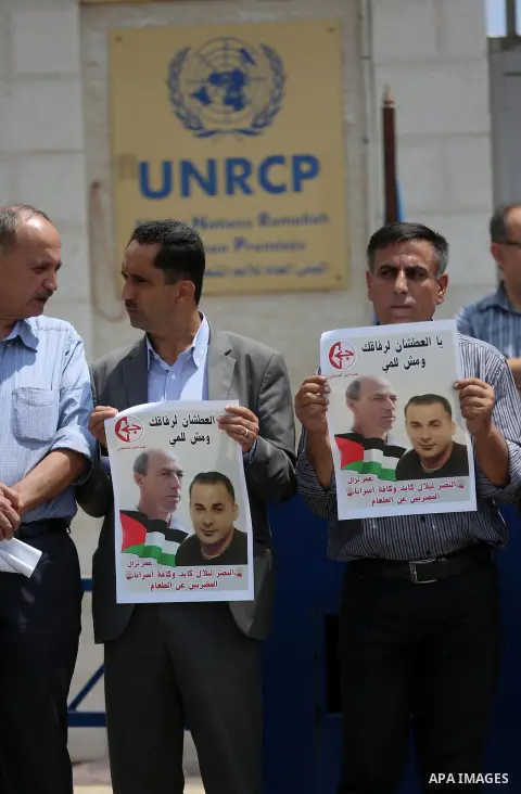 Palestinians take part during a protest calling for the release of Palestinian journalist Omar Nazzal and Bilal Kayed a Palestinian prisoner on hunger strike, in front of UN headquarters in the West Bank city of Ramallah...