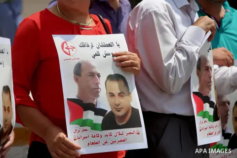 Palestinians take part during a protest calling for the release of Palestinian journalist Omar Nazzal and Bilal Kayed a Palestinian prisoner on hunger strike, in front of UN headquarters in the West Bank city of Ramallah...