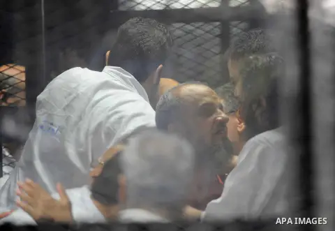 Egyptian Muslim Brotherhood defendants are seen behind bars during their trial, in a case known in media as "Rabaa Operations Room", in Cairo, on Aug. 09, 2016. Photo by Amr Sayed