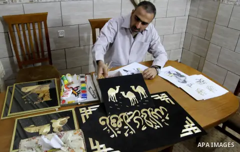 A Palestinian artist, Hossam Abed, fills the paintings from straw "wheat stalks", at his house, in Rafah in the southern Gaza strip, on August 10, 2016. Photo by Abed Rahim Khatib