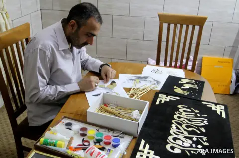 A Palestinian artist, Hossam Abed, fills the paintings from straw "wheat stalks", at his house, in Rafah in the southern Gaza strip, on August 10, 2016. Photo by Abed Rahim Khatib