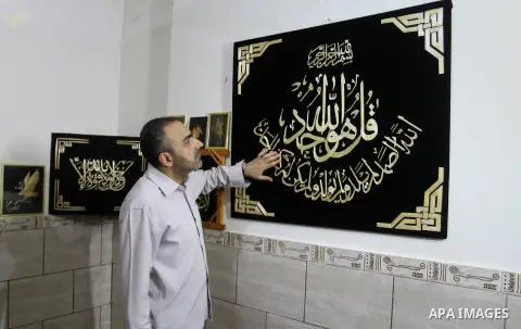 A Palestinian artist, Hossam Abed, fills the paintings from straw "wheat stalks", at his house, in Rafah in the southern Gaza strip, on August 10, 2016. Photo by Abed Rahim Khatib