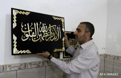 A Palestinian artist, Hossam Abed, fills the paintings from straw "wheat stalks", at his house, in Rafah in the southern Gaza strip, on August 10, 2016. Photo by Abed Rahim Khatib