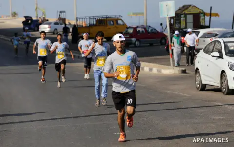Palestinian youths take part in a marathon to mark the International Youth Day, in Gaza city, on Aug. 12, 2016. Photo by Mohammed Asad