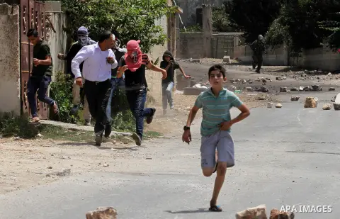 Palestinian protesters run during clashes with Israeli security forces following a weekly demonstration against the expropriation of Palestinian land by Israel on August 12, 2016, in the village of Kfar Qaddum, near Nabl...