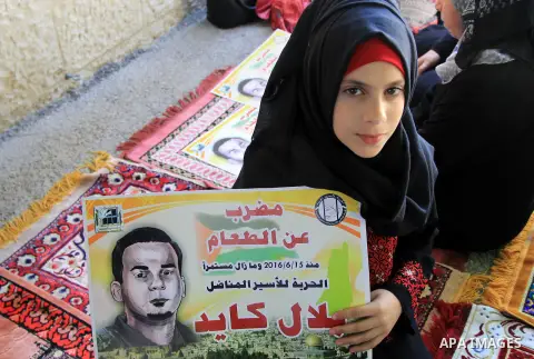 Palestinian protestors hold posters against administrative detention and in support of Palestinian prisoner Bilal Kayed (portrait), who has been fasting for almost two months over his detention without trial, as they dem...
