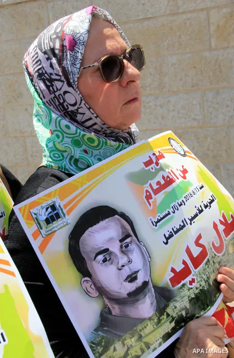 Palestinian protestors hold posters against administrative detention and in support of Palestinian prisoner Bilal Kayed (portrait), who has been fasting for almost two months over his detention without trial, as they dem...