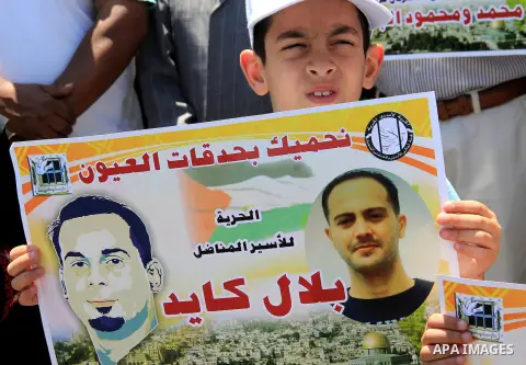 Palestinian protestors hold posters against administrative detention and in support of Palestinian prisoner Bilal Kayed (portrait), who has been fasting for almost two months over his detention without trial, as they dem...