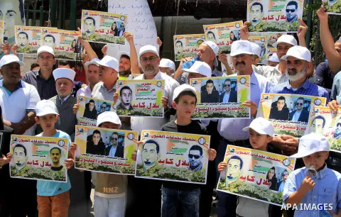 Palestinian protestors hold posters against administrative detention and in support of Palestinian prisoner Bilal Kayed (portrait), who has been fasting for almost two months over his detention without trial, as they dem...