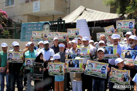 Palestinian protestors hold posters against administrative detention and in support of Palestinian prisoner Bilal Kayed (portrait), who has been fasting for almost two months over his detention without trial, as they dem...