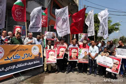 Palestinians hold posters against administrative detention and in support of Palestinian prisoner Bilal Kayed (portrait), who has been fasting for almost two months over his detention without trial, in Gaza city, on Augu...
