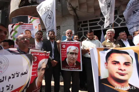 Palestinians hold posters against administrative detention and in support of Palestinian prisoner Bilal Kayed (portrait), who has been fasting for almost two months over his detention without trial, in Gaza city, on Augu...
