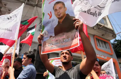 Palestinians hold posters against administrative detention and in support of Palestinian prisoner Bilal Kayed (portrait), who has been fasting for almost two months over his detention without trial, in Gaza city, on Augu...