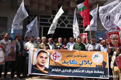 Palestinians hold posters against administrative detention and in support of Palestinian prisoner Bilal Kayed (portrait), who has been fasting for almost two months over his detention without trial, in Gaza city, on Augu...