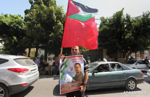 Palestinians hold posters against administrative detention and in support of Palestinian prisoner Bilal Kayed (portrait), who has been fasting for almost two months over his detention without trial, in Gaza city, on Augu...