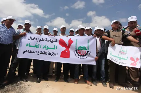 Palestinian traders hold banners during a protest against the Israeli authorities to withdraw permits for some of the traders and to prevent their entry into the West Bank, in front of the Erez crossing point with Israel...
